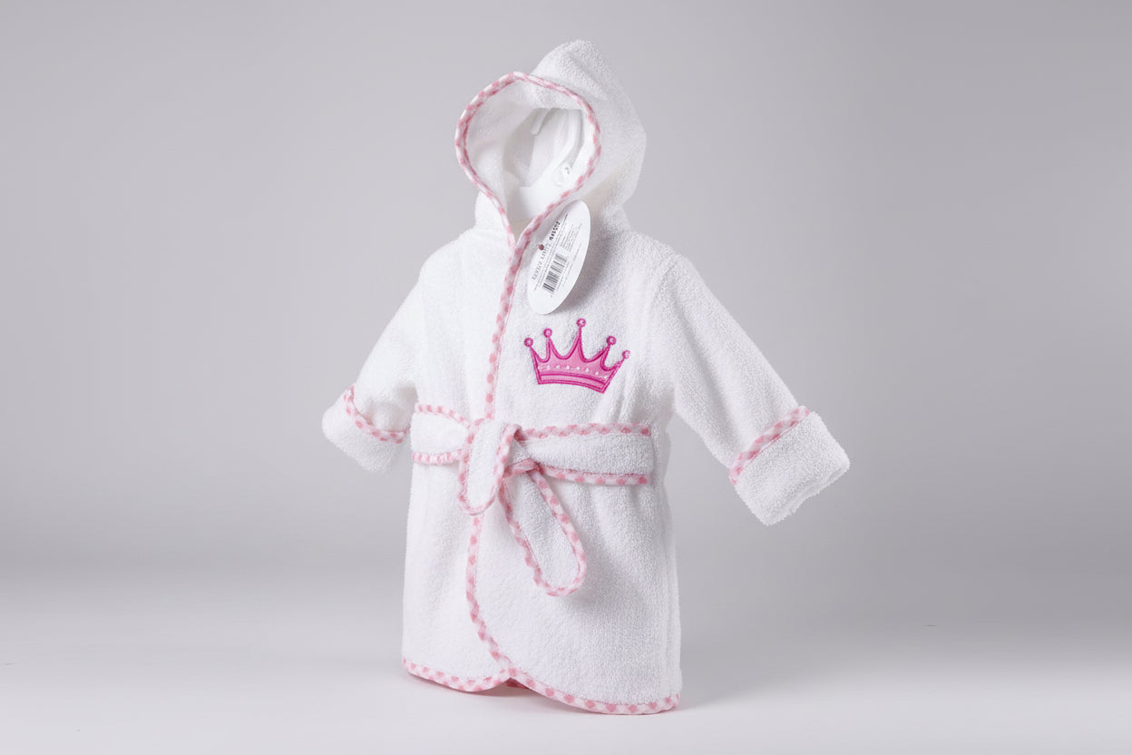 White children's robe with pink accents and a crown emblem on a green textured background